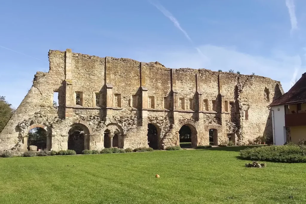 A ruined wall and mullioned doorway at the Cistercian Abbey of Cârța, Romania.