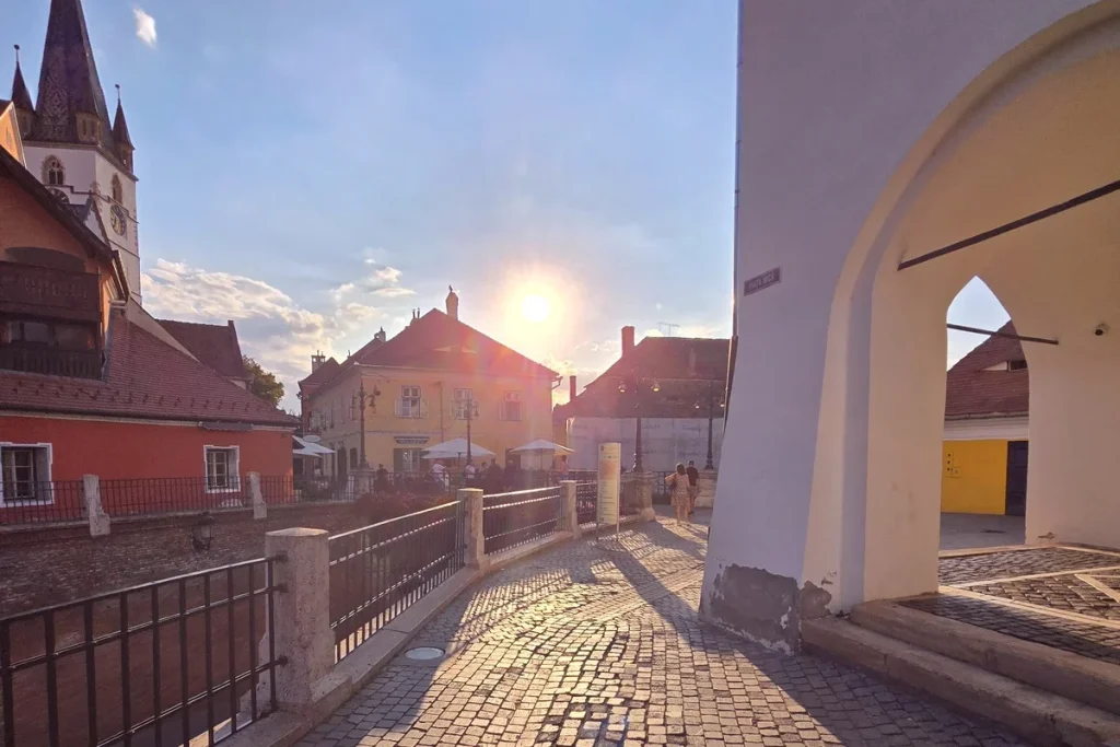 Pedestrian path beside the Bridge of Lies in Sibiu's historic centre at sunset.