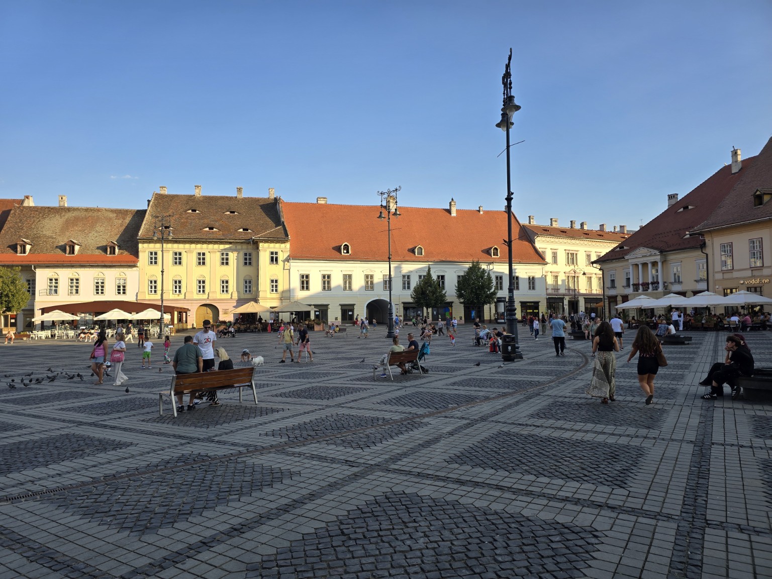 Piața Mare in Sibiu's historic centre, with historic buildings and people crossing the square.